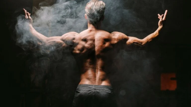 Atleta posando de espaldas para denostar su aumento de masa muscular