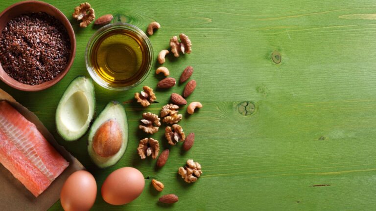 Variedad de alimentos ricos en proteínas como salmón, aguacate, huevos y nueces, fuentes de los 10 aminoácidos no esenciales para una dieta equilibrada
