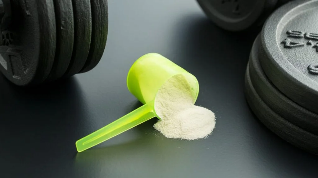 Pesas y suplemento de proteína en polvo preparados para un entrenamiento de fuerza orientado a aumentar la masa muscular.