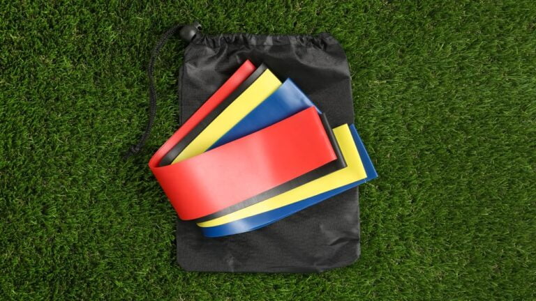 Set de bandas elásticas en una bolsa negra sobre césped, ideal para entrenar al aire libre