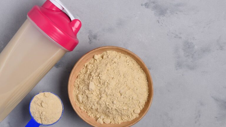 Detalle de proteína en polvo con batidora y tazón, destacando el enfoque en suplementación para la recuperación muscular.
