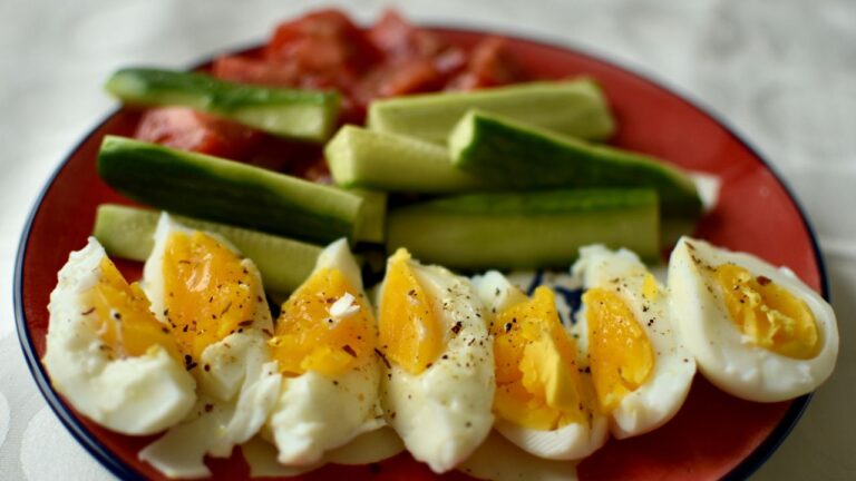 Desayuno alto en proteínas con huevos a la copa, verduras frescas y aguacate, un comienzo saludable y lleno de sabor.