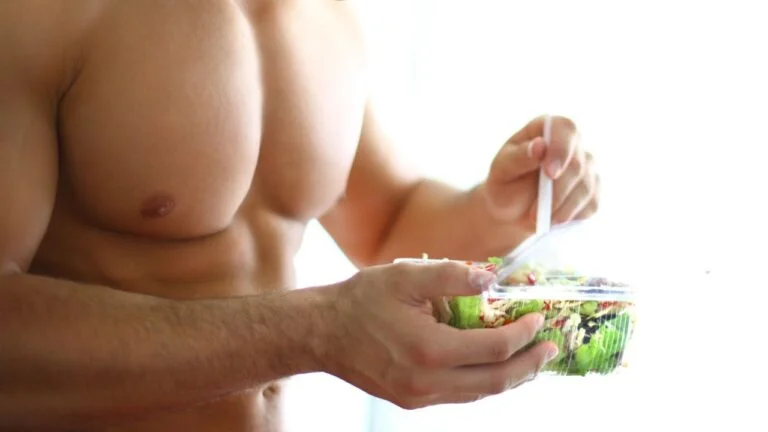 Alimentación posentrenamiento mostrando un plato de ensalada saludable para optimizar la recuperación muscular y el rendimiento atlético.