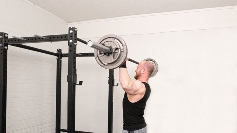 Entrenamiento de hombros con levantamiento de barra en rack de potencia casero.