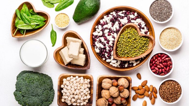 Variedad de legumbres y semillas en recipientes de madera, fuente rica en proteínas de origen vegetal.