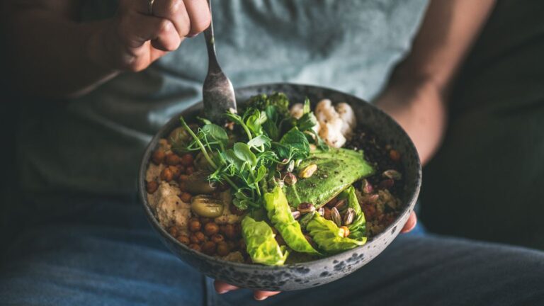Bol de ensalada con garbanzos y vegetales verdes, una comida nutritiva con proteínas de origen no animal."