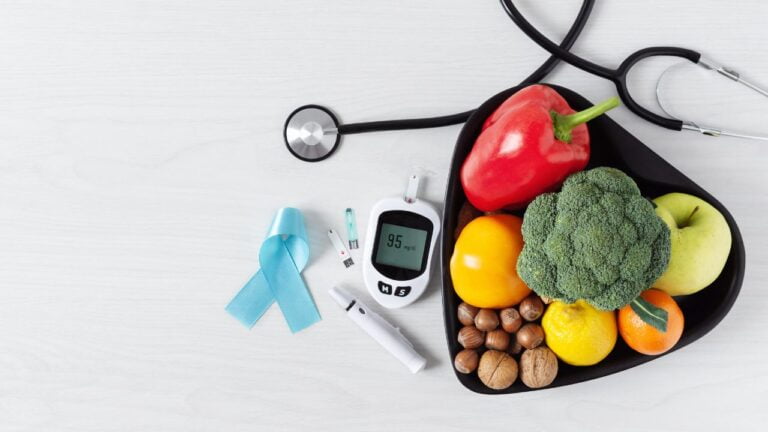Selección de frutas y frutos secos dispuestos en forma de corazón con equipo médico, simbolizando una alimentación saludable para el control de la diabetes.