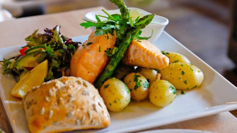 Plato de salmón rosado acompañado de patatas al vapor y ensalada fresca, perfecto para unas cenas saludables después de entrenar.