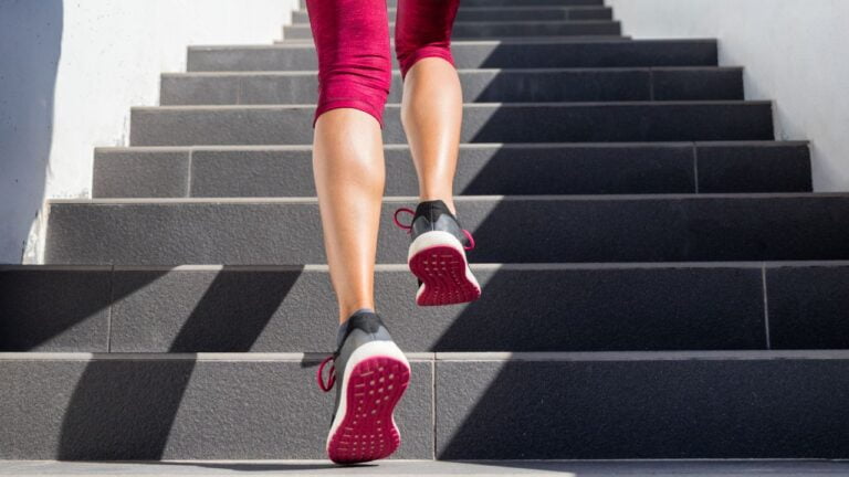 Persona subiendo escaleras como parte de un entrenamiento de cardio, una manera simple de ejercitar en cualquier lugar.