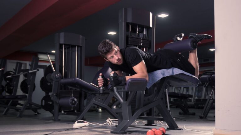 Entrenamiento unilateral de femoral con equipo de gimnasio profesional.
