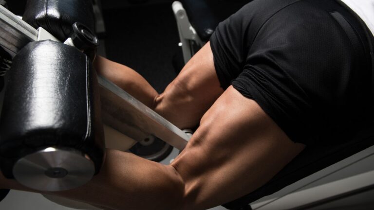Intenso trabajo de piernas utilizando equipo de gimnasio para mejorar la musculatura femoral.