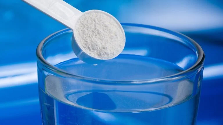 Dosis medida de creatina micronizada lista para mezclar, enfatizando la importancia de la dosificación adecuada.