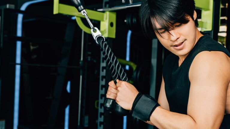 Ejercicio para tríceps utilizando polea en el gimnasio para fortalecimiento del brazo.