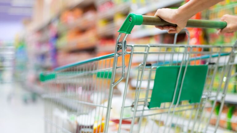 Carrito de supermercado en el pasillo de la tienda, simbolizando la compra de ingredientes saludables.