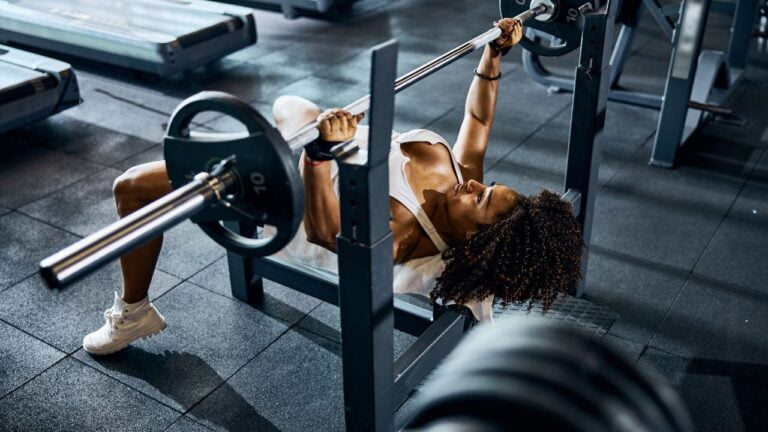 Entrenamiento intenso de pectorales con press en banco en el centro de fitness.