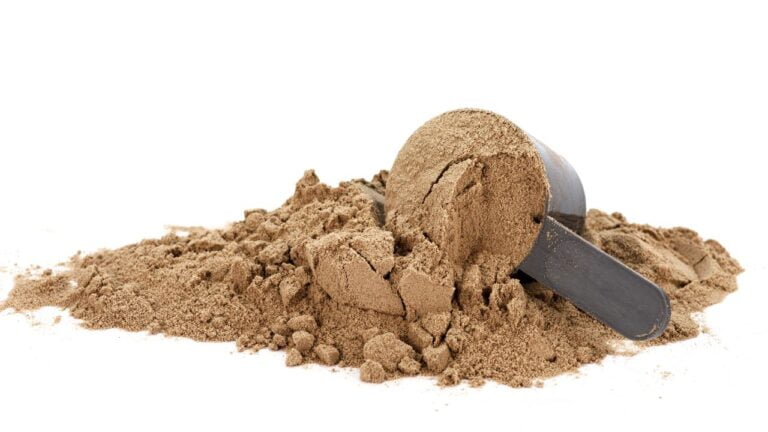Proteína en polvo con cuchara medidora sobre fondo blanco, nutrición deportiva esencial.