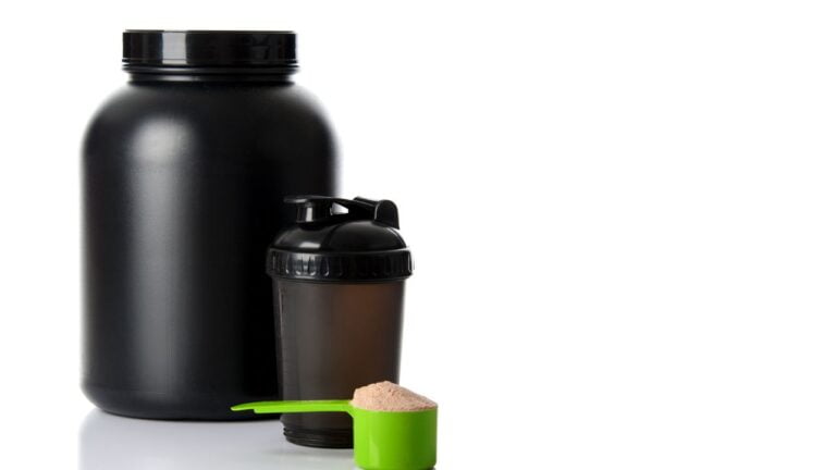 Bote de suplemento negro con mezclador y dosificador de proteínas para atletas.