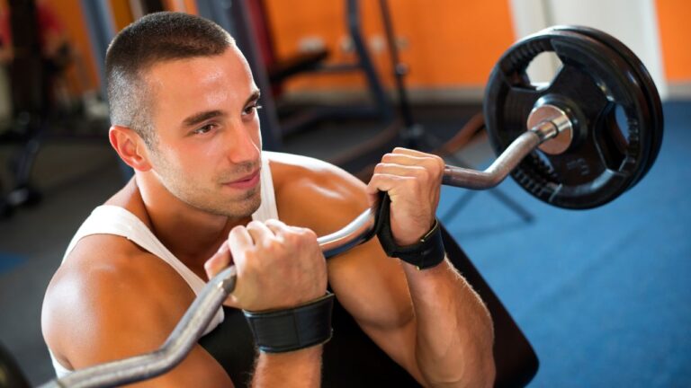 Entrenamiento intensivo de brazos con barra, enfocado en mejorar la fuerza del bíceps en un gimnasio
