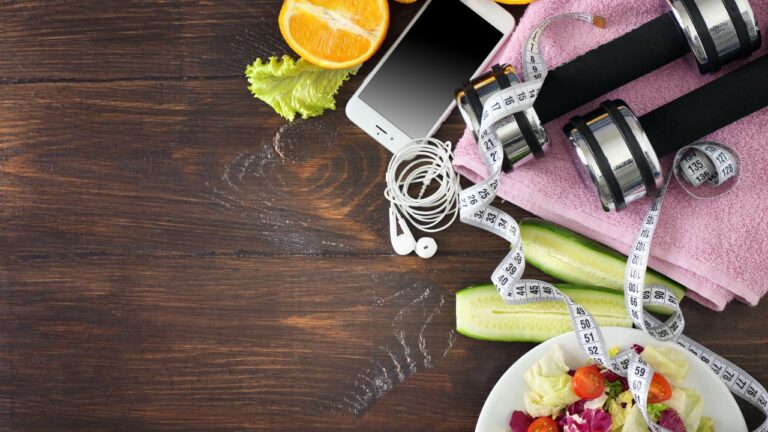 Equipo de entrenamiento con comida saludable en madera, integrando ejercicio y nutrición para un estilo de vida activo y equilibrado.